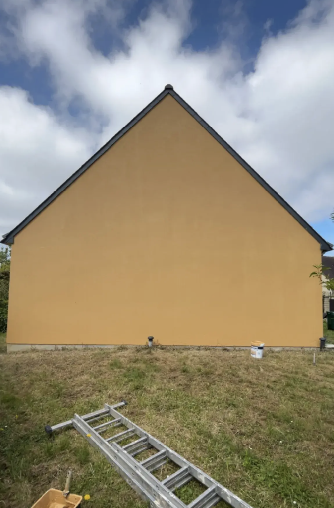Application d’enduit de façade par un professionnel du bâtiment