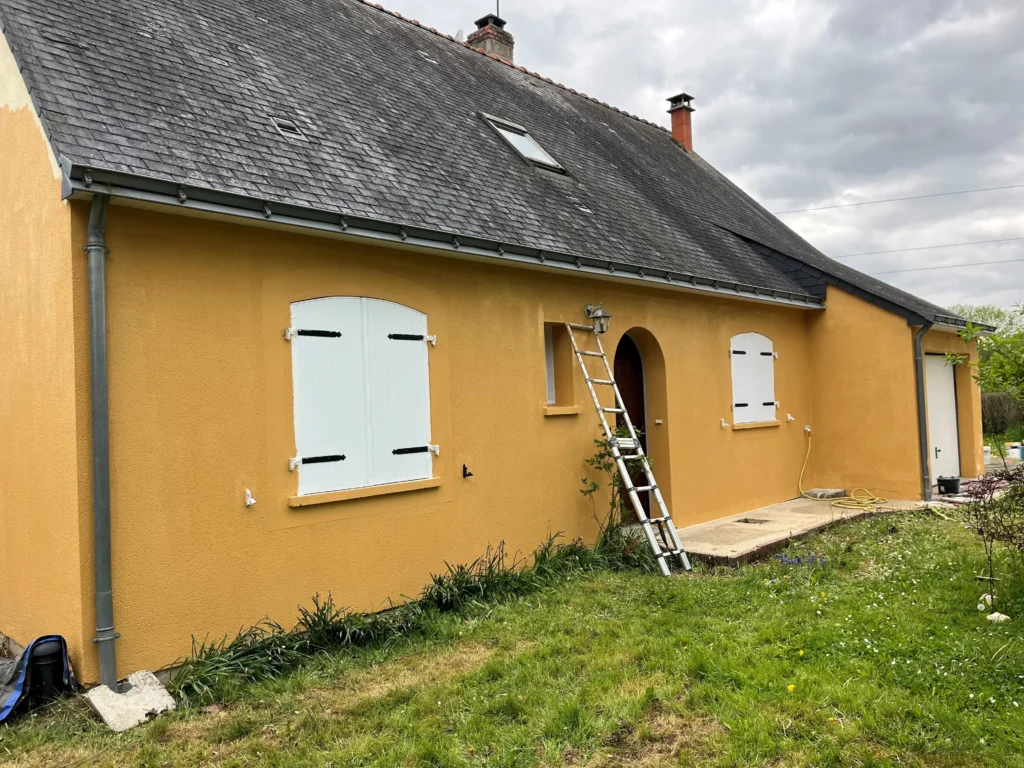 Artisan réalisant un ravalement de façade à l’échafaudage